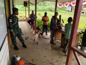 Babinsa Okbibab Bersama Masyarakat Gelar Karya Bakti Bersihkan Kantor Distrik