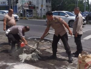 Polisi Bersama TNI dan Warga Tambal Jalan Berlubang di Kota Malang Cegah Kecelakaan 
