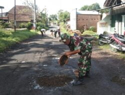 Sikap Peduli Babinsa Serda Epi Bersama Warga Timbun Jalan Berlubang