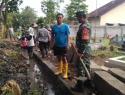 Takut Air Meluap, Babinsa Sertu L. Sugianto Dan Warga Perbaiki Pagar Makam