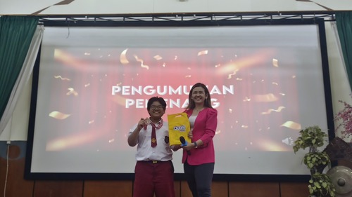 Priska Sahanaya memberikan medali pada siswa SD Katolik Sang Timur yang mendapatkan poin tertinggi pada sesi workshop. Sumber gambar: Dok. Pribadi.