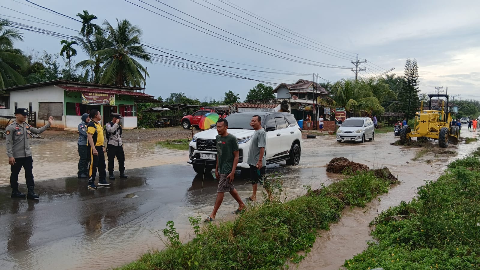 POLSEK TALANG UBI ATUR LALIN DAN BANTU PENGURANGAN DEBIT BANJIR DI SIMPANG RAJA